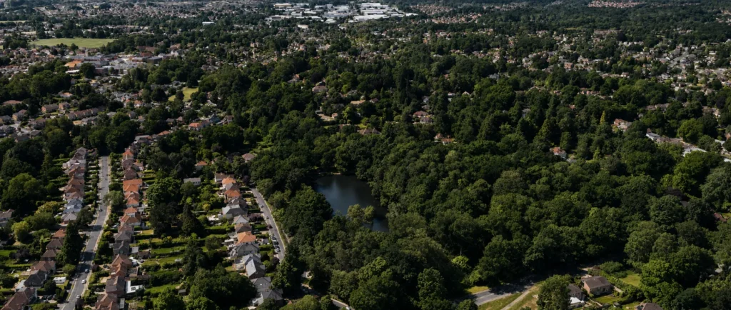 Aerial view over Chandler’s Ford, showing residential streets, dense woodland and Hiltingbury Lake surrounded by greenery.
