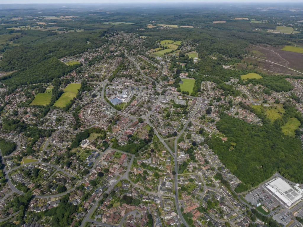 Aerial view of Verwood, showing the town’s residential streets, Verwood Hub area, surrounding woodland, open green spaces and countryside beyond.
